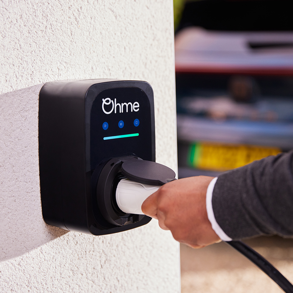 Ohme EV charger in use at home, showing charging cable being connected to the unit - available from Evergy, Thame's local EV charger supplier.